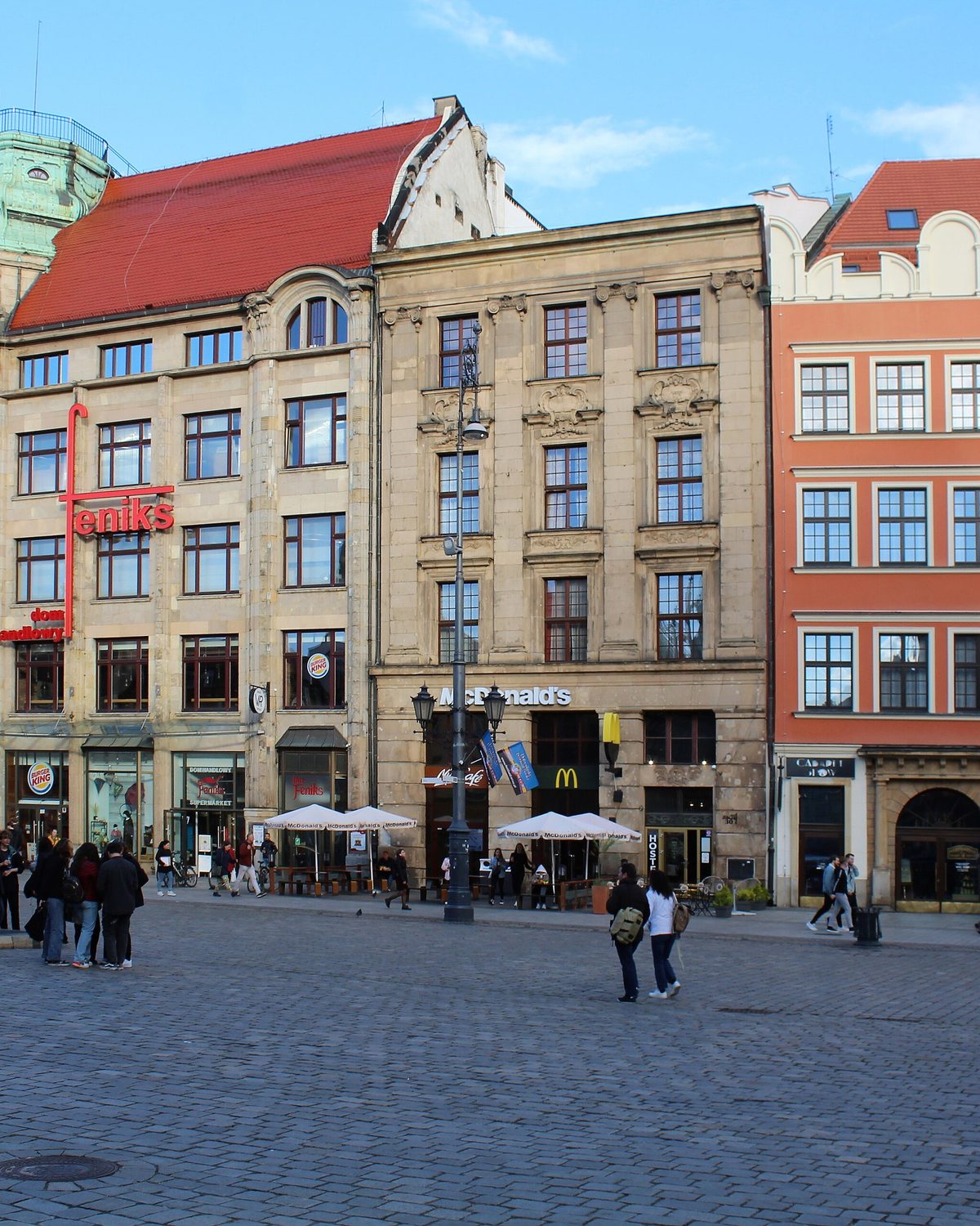 Wrocławski Rynek z poziomu ulicy, ze stolikami kawiarni przed kolorowymi kamienicami